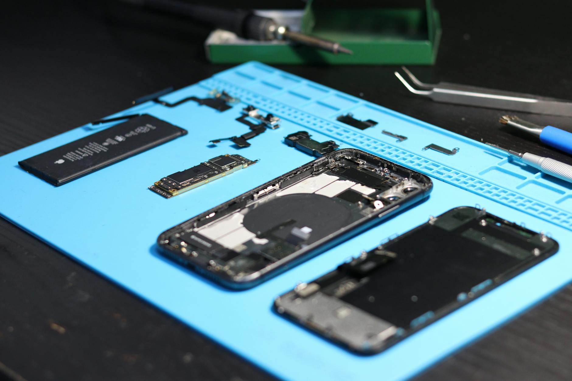 Robotic diagnostic enclosure inspecting a smartphone, representing automated grading workflows on a refurbishment floor.